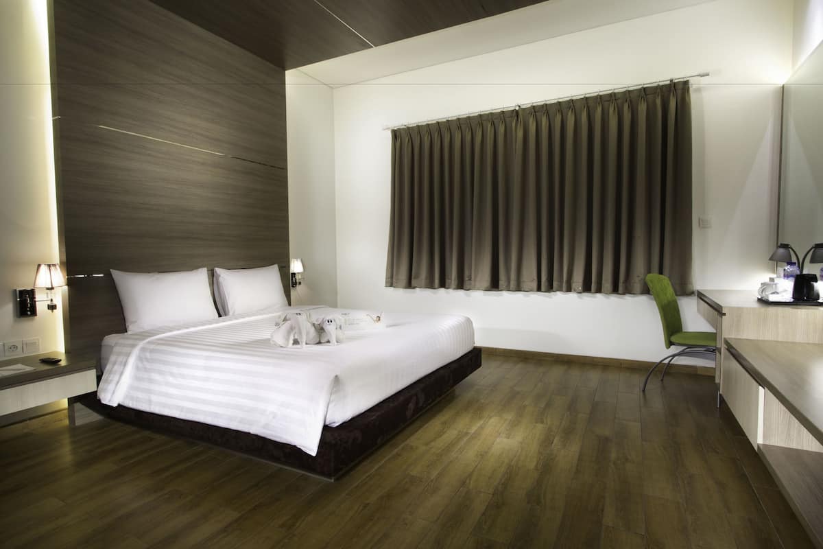 Una habitación de hotel moderna con una cama grande, un escritorio y una silla.