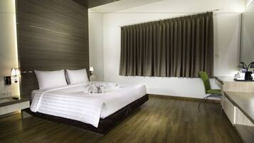 A modern hotel room with a large bed, a desk, and a chair.