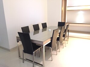 Une salle de conférence moderne avec une table en verre et des chaises noires.