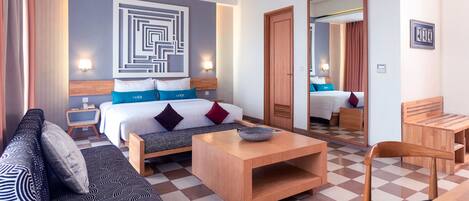 Une chambre d’hôtel comprenant un lit, un canapé, une table basse et un coin repas.