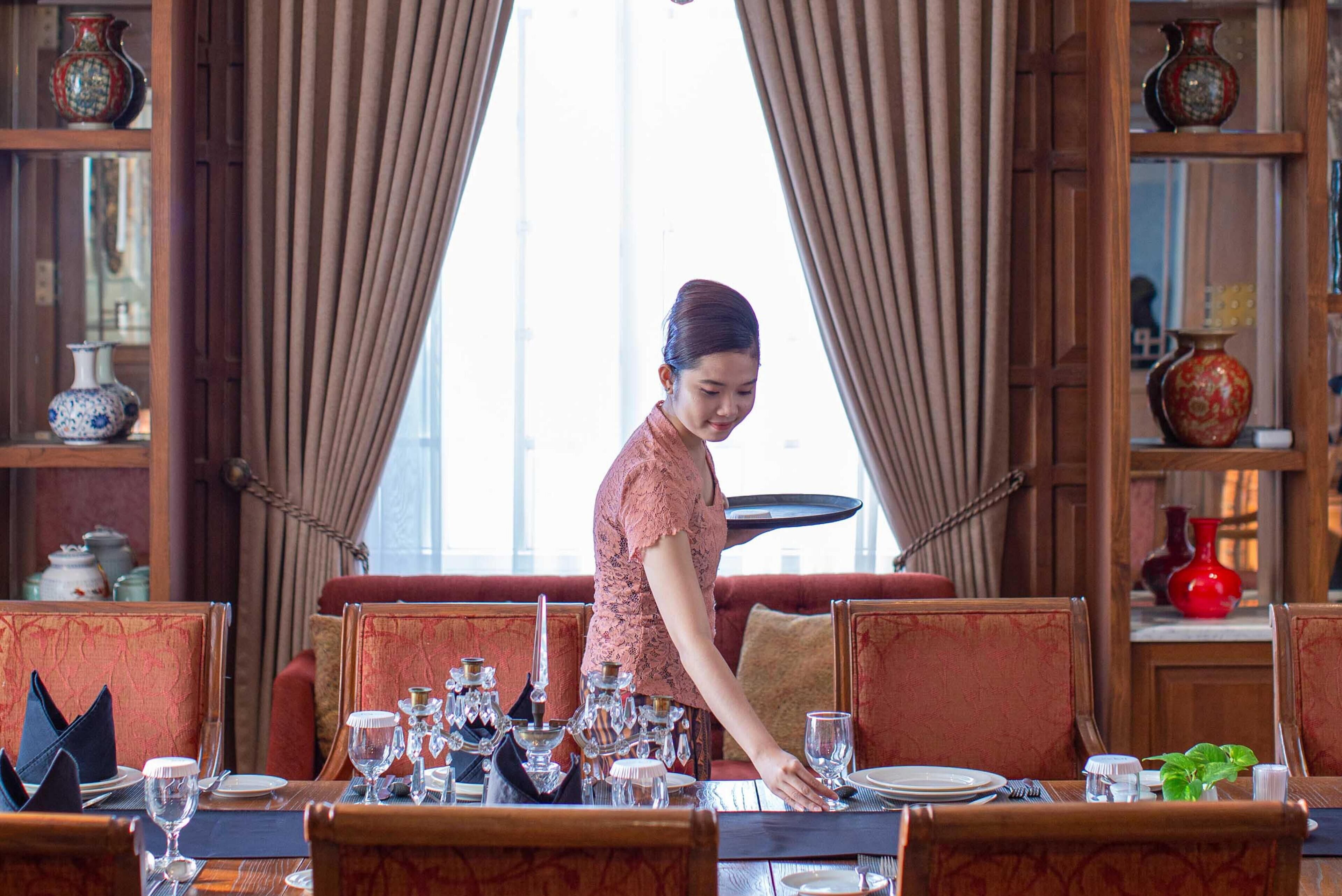 A dining area with a server attending to a table.