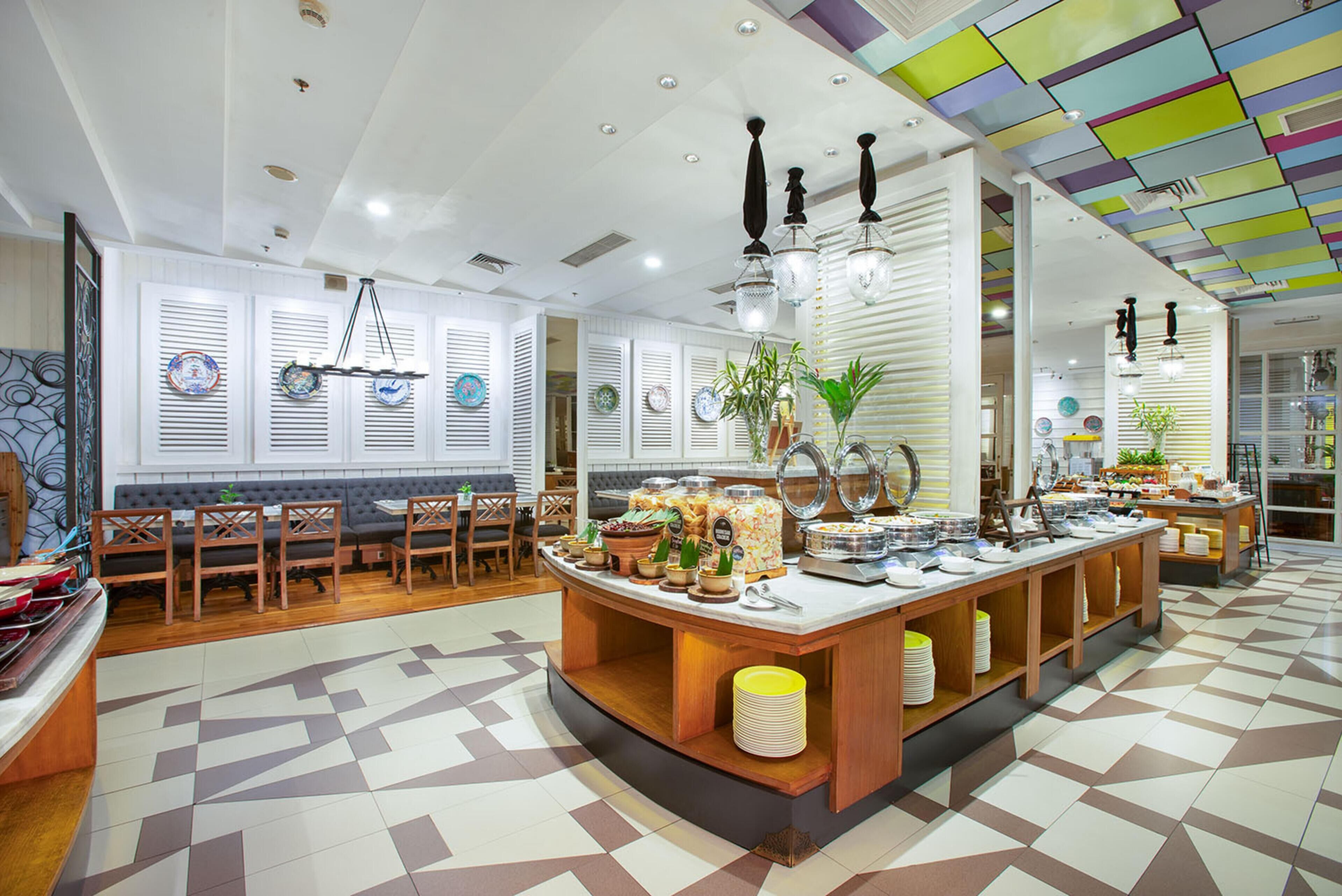 Un comedor moderno con un bufé central, muebles de madera y platos decorativos en las paredes.