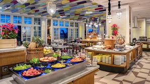 A buffet with various food items and a colorful ceiling. - THE 1O1 Bogor Suryakancana (Bogor)