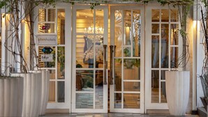 A hotel entrance with glass doors, a sign for 'phmhotels', and a 'Check In' sign. - THE 1O1 Bogor Suryakancana (Bogor)
