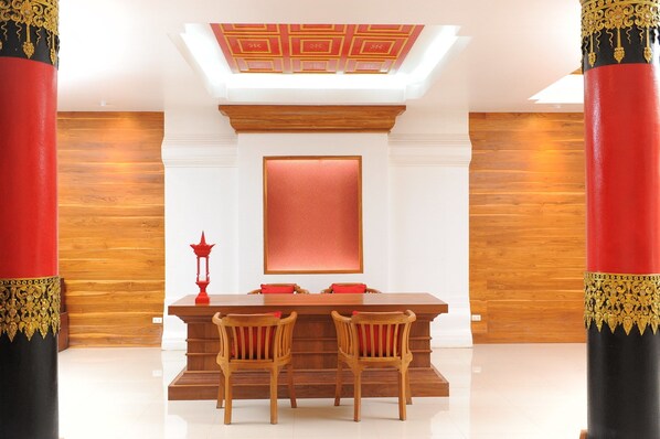 Un comedor con una mesa de madera, dos sillas y una vela roja.