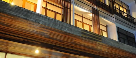 A multi-story hotel with a modern design, featuring balconies and large windows.
