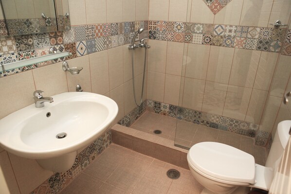A bathroom with a sink, toilet, and shower.