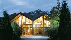 Een modern huis met grote glasramen en een schuin dak.