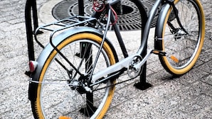 A bicycle with a basket and a red seat parked on a paved surface. - Archipelago Hostel Old Town (Stockholm)