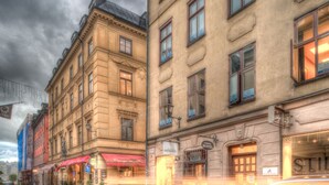 A historic building with a traditional facade, a hostel sign, and a storefront with a red awning. - Archipelago Hostel Old Town (Stockholm)