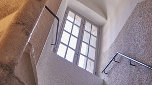 A spiral staircase with a view of a window at the top. - Archipelago Hostel Old Town (Stockholm)