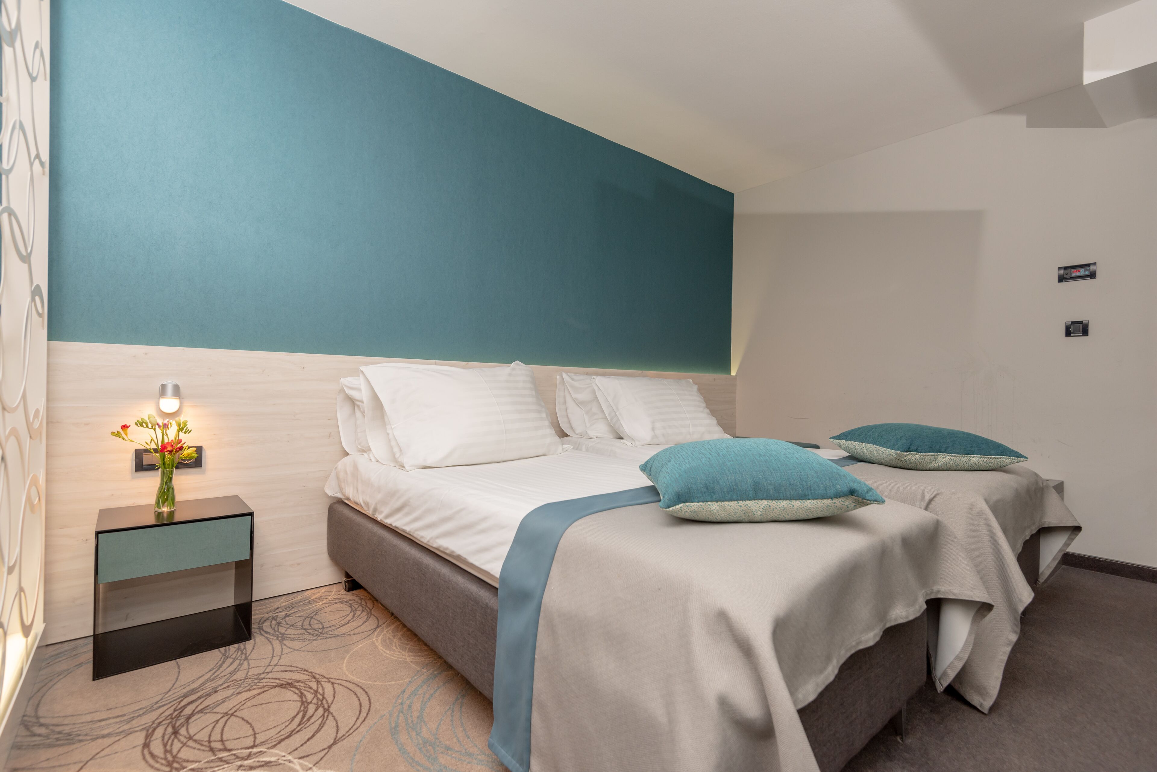 Un dormitorio moderno con una cama grande, dos mesitas de noche y una mesita auxiliar.