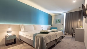 A modern hotel room with a large bed, bedside tables, a desk, and a TV. - Hotel Kolovare (Zadar)