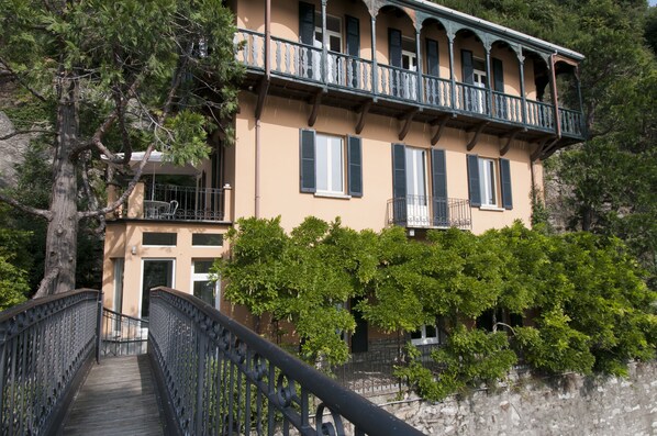 Ein Gebäude mit Balkon und einer Treppe, die zum Eingang führt.