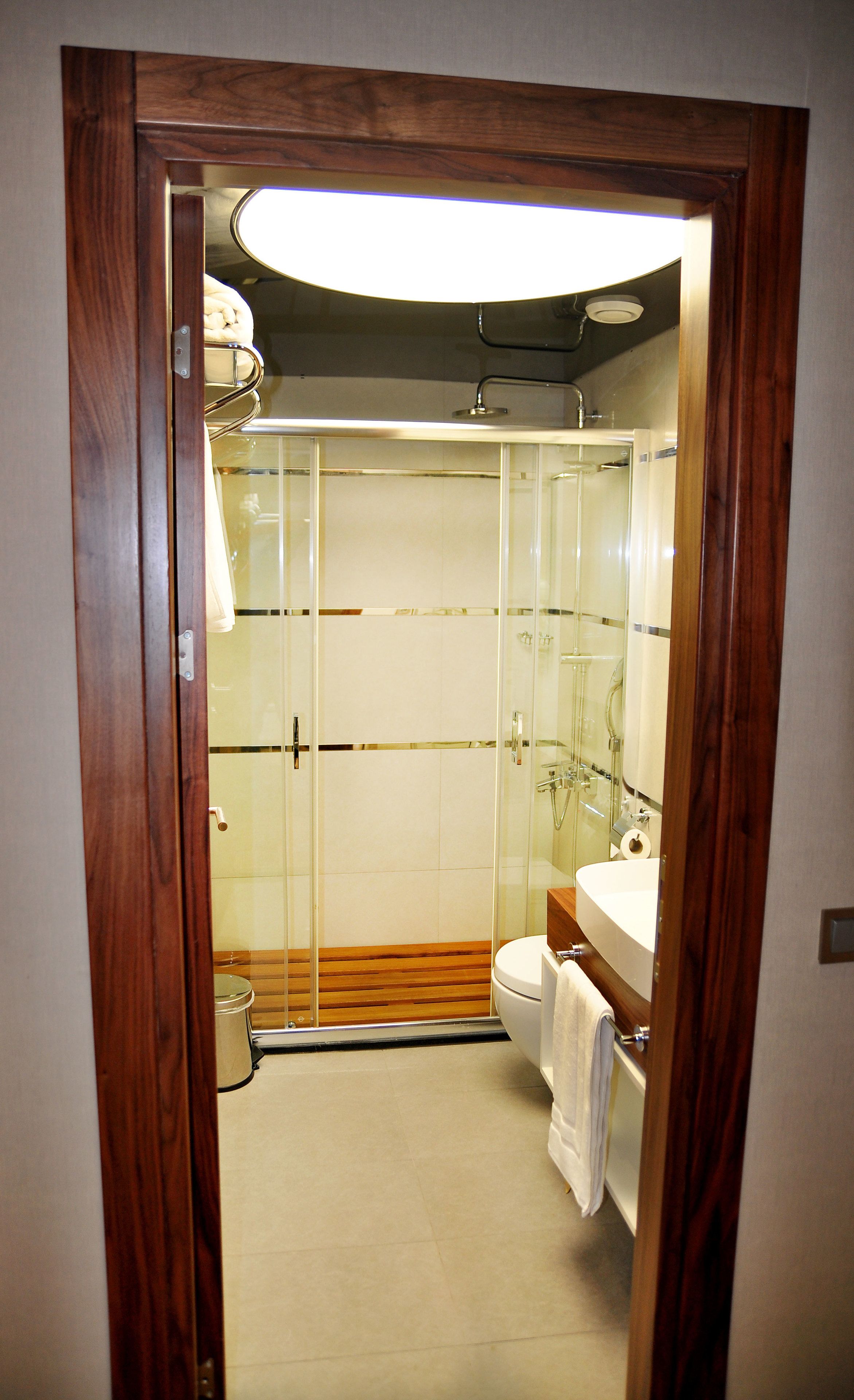 A modern bathroom with a glass-enclosed shower, a white sink, and a toilet.