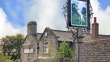 Un edificio de piedra tradicional con un letrero que indica el pub 'The White Horse'.