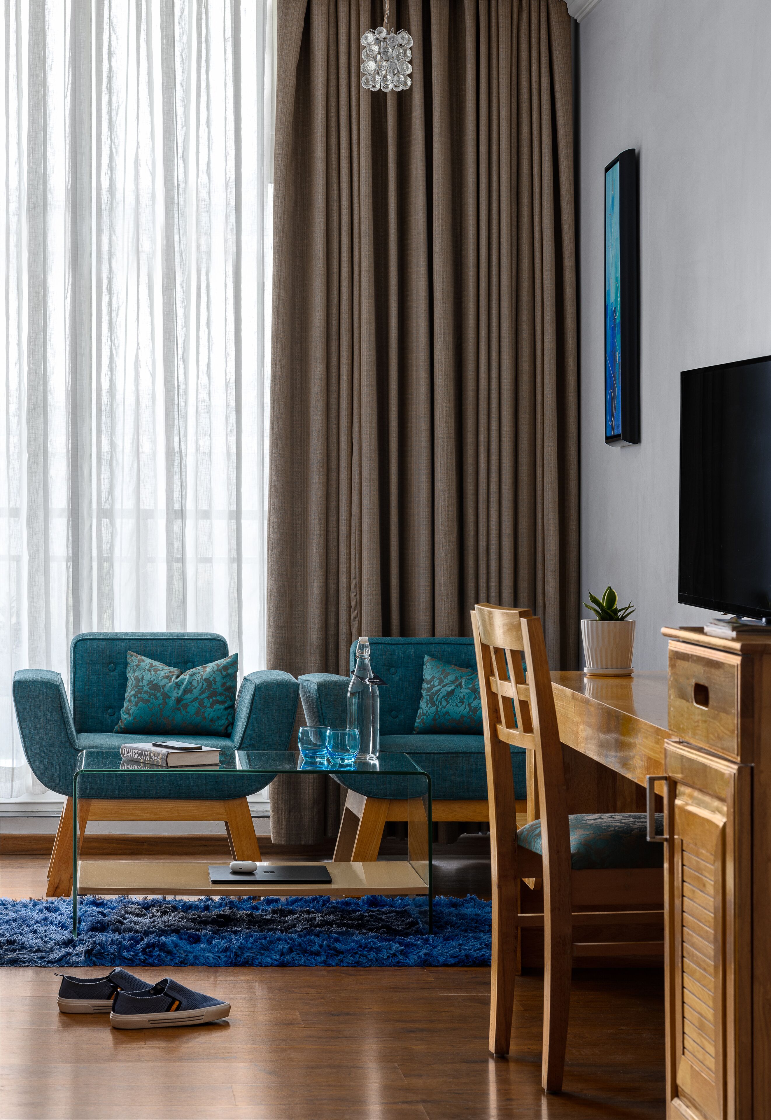 A modern living room with a sofa, a dining table, and a TV.