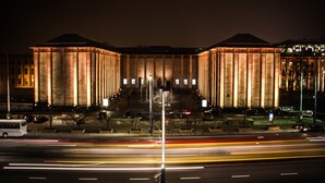 A large, illuminated building with a symmetrical facade and a central staircase leading to an entrance. - Smolna Apartments by Your Freedom (Warsaw)