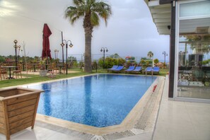 Alberca al aire libre por temporada y sombrillas en la alberca