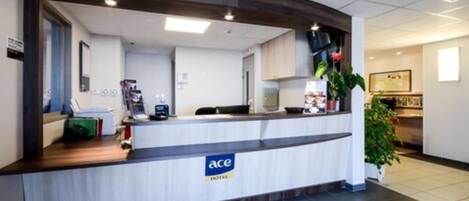 Una recepción con un letrero que dice "ace HOTEL".
