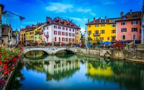 Explore a charming European town with a picturesque canal, colorful buildings, and a historic stone bridge.