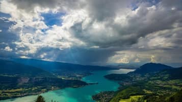 Une vue panoramique d’un paysage côtier, avec une vaste étendue d’eau, entourée de collines et de verdure.