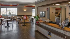 Un restaurante moderno con barra, mesas y sillas.