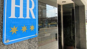 A blue sign with "HR" and three stars, mounted on a granite wall.