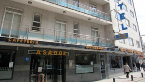 Un hotel de varios pisos con un restaurante y una cafetería visibles en la planta baja.