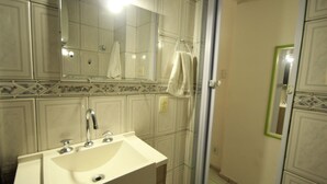 Un baño con lavamanos, espejo y ducha.