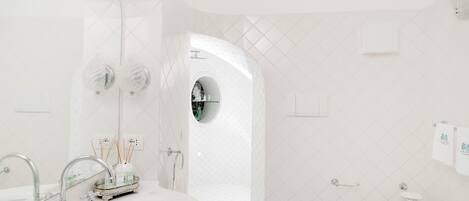 Un baño moderno con una bañera independiente, inodoro y lavamanos con tocador.