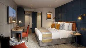 A modern hotel room with a bed, desk, chair, and a view of the hallway. - Bernwood Park Hotel (Aylesbury)