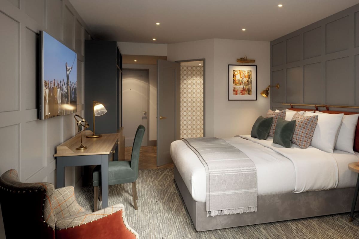 A modern bedroom with a bed, bedside tables, a desk, and a chair.
