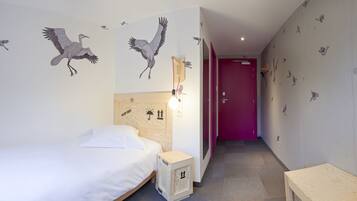 Ein Hotelzimmer mit einem Bett, einem Holzkopfbrett, einer kleinen Holzkabine und einer lilafarbenen Tür.