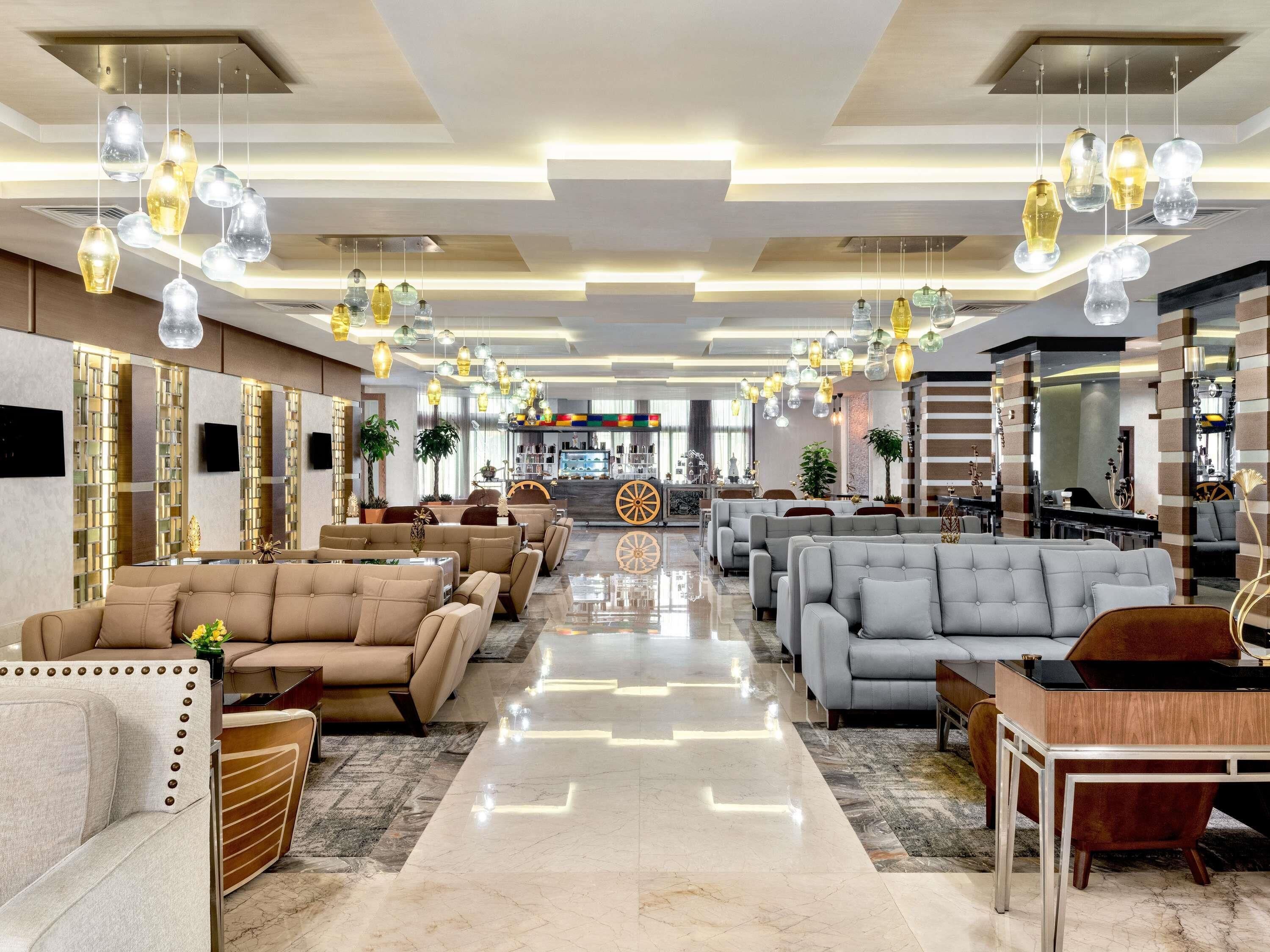 A spacious lobby with modern seating, a bar area, and a central decorative feature.