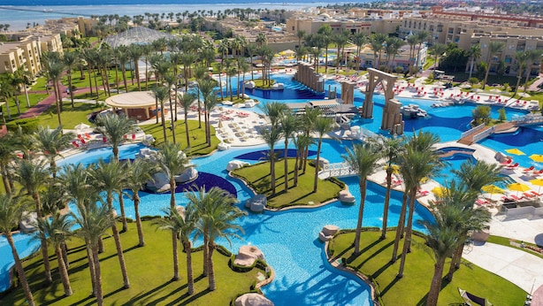 A resort with multiple swimming pools, palm trees, and lounge areas. - Rixos Premium Seagate (Sharm El Sheikh)