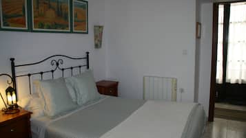 A bedroom with a bed, nightstand, lamp, and wall art.