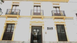 A building with a classic architectural style, featuring ornate balconies and a central entrance with a sign reading "Pensión el Portillo". - Pensión El Portillo (Córdoba)
