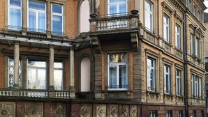 A corner building with ornate architectural details, large windows, and a balcony. - Adonis Hotel Strasbourg (Strasbourg)