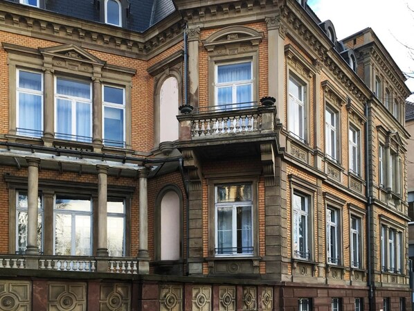 A corner building with ornate architectural details, large windows, and a balcony. - Adonis Hotel Strasbourg (Strasbourg)