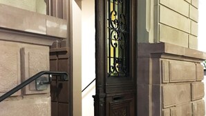 A grand entrance with a decorative iron gate, a red carpet, and a sign indicating access to the breakfast area. - Adonis Hotel Strasbourg (Strasbourg)