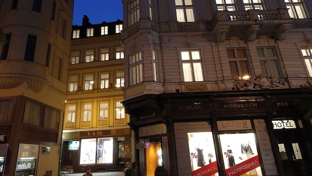 En historisk bygning med detaljeret arkitektur, herunder et markant tårn og mange vinduer.