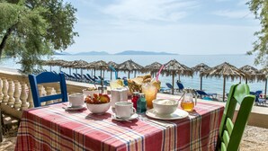 Ein gedeckter Tisch mit Frühstücksgebäck und Blick auf das Meer.