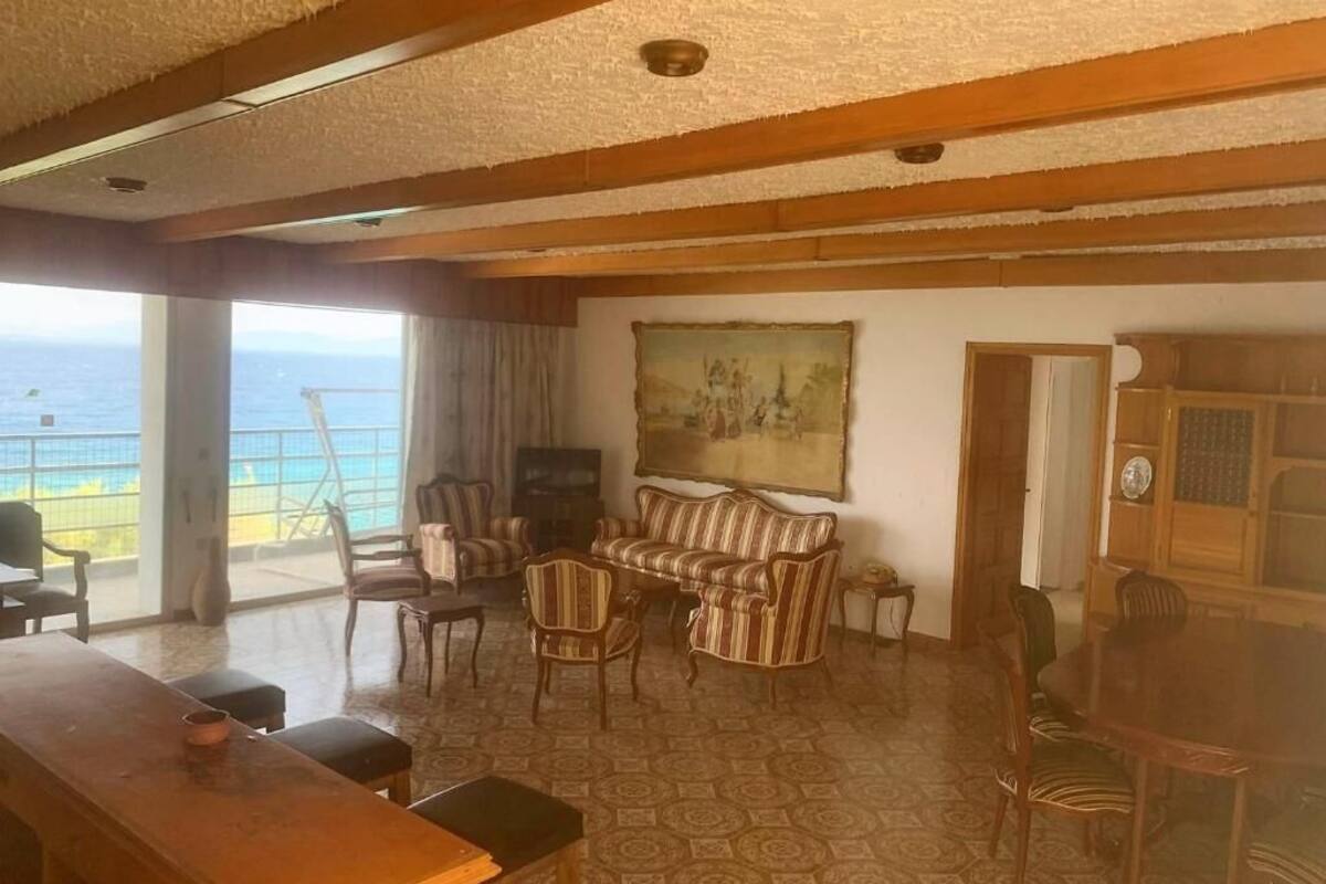 A living room with a sofa, chairs, a coffee table, a TV, and a dining table.
