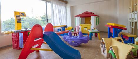 A children's play area with a slide, playhouse, and various toys.
