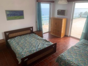 A bedroom with a bed, a wardrobe, a balcony with a view of the sea, and a painting on the wall. - SUN HOTEL KINETA “Beach Front” (Megara)