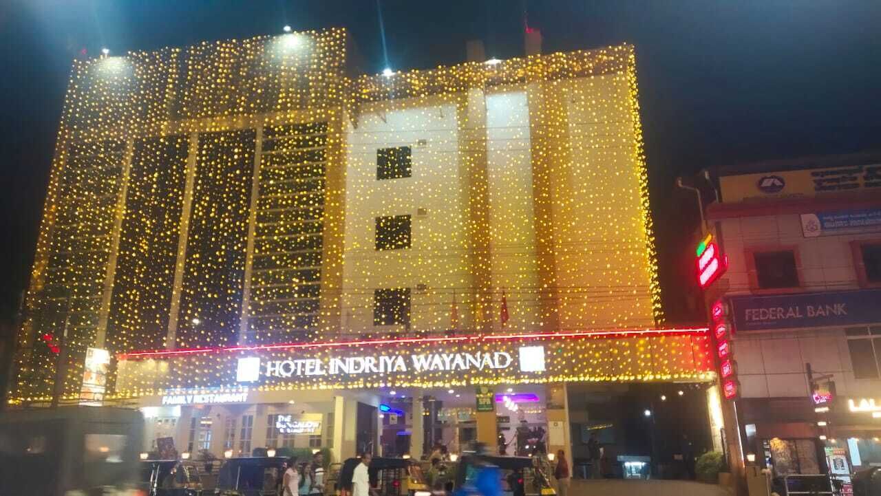 A hotel with a prominent sign, multiple floors, and a well-lit facade.