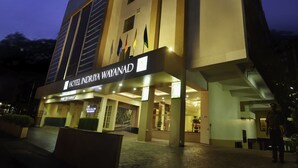 Un hotel moderno con un letrero llamativo que dice "HOTEL INDIYA WAYANAD".