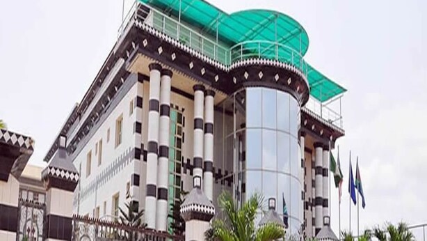 A large building with a distinctive architectural style, featuring a central cylindrical tower and a covered balcony area. - Royalview Hotel And Suites (Lagos)