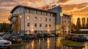 Un hotel dal design moderno, con diversi posti auto e un ingresso ben visibile.